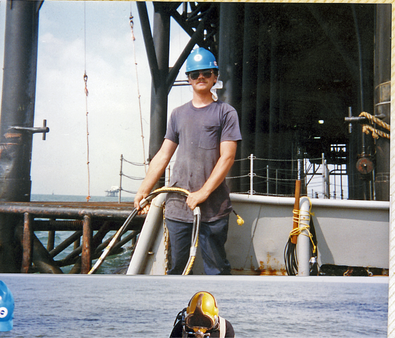 Commercial diver tending an umbilical from an offshore platform in the Gulf of Mexico